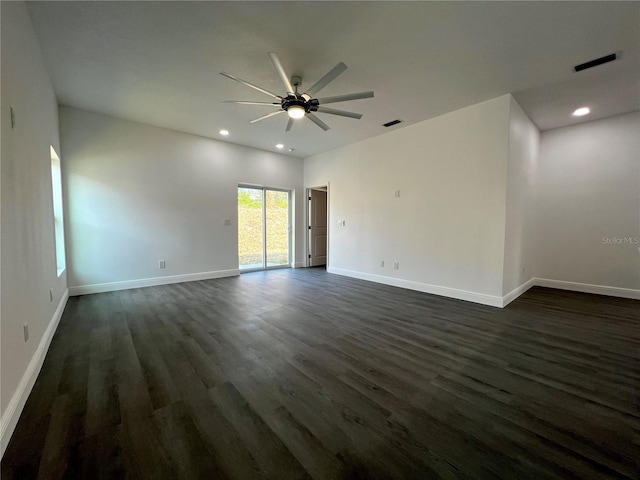 unfurnished room featuring dark wood-type flooring, baseboards, visible vents, and ceiling fan