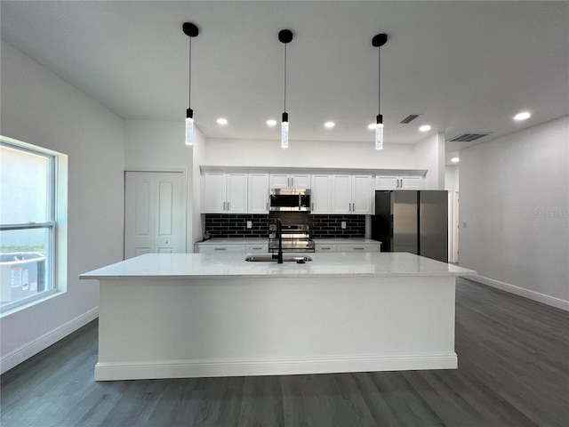 kitchen featuring tasteful backsplash, visible vents, white cabinets, stainless steel appliances, and a sink