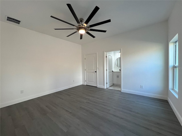 unfurnished bedroom featuring visible vents, ensuite bathroom, baseboards, and dark wood-style flooring