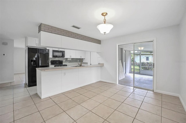 1986 Big Oak Dr, South Daytona, FL 32119 - kitchen with light tile patterned floors, visible vents, a peninsula, decorative backsplash, and black appliances