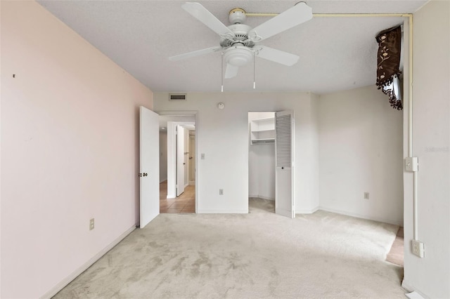 unfurnished bedroom featuring baseboards, visible vents, ceiling fan, a closet, and light carpet