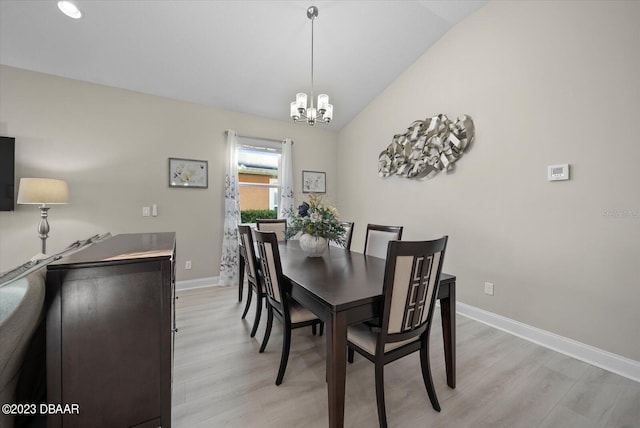 dining space with vaulted ceiling, a notable chandelier, baseboards, and light wood-type flooring