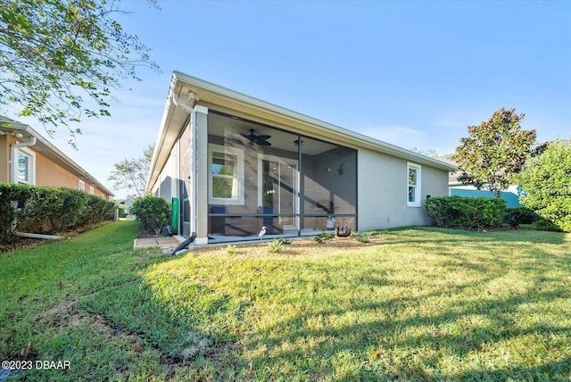 back of house with a yard, a sunroom, and ceiling fan