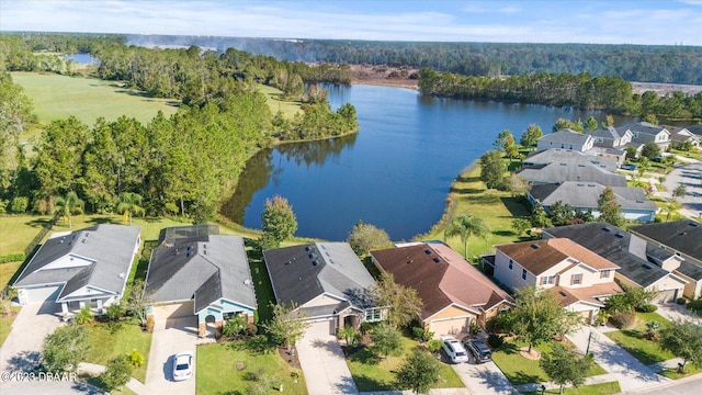 birds eye view of property with a residential view, a wooded view, and a water view