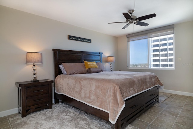 tiled bedroom featuring a ceiling fan and baseboards