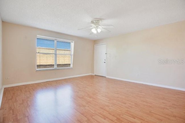 unfurnished room with light wood finished floors, a textured ceiling, baseboards, and ceiling fan