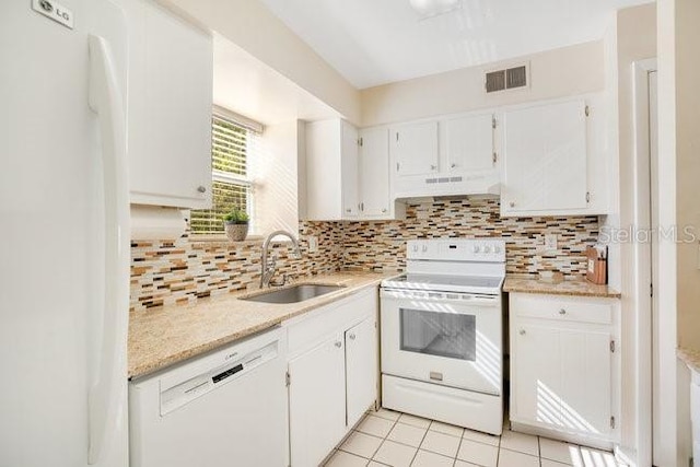 kitchen featuring white appliances, visible vents, a sink, decorative backsplash, and under cabinet range hood