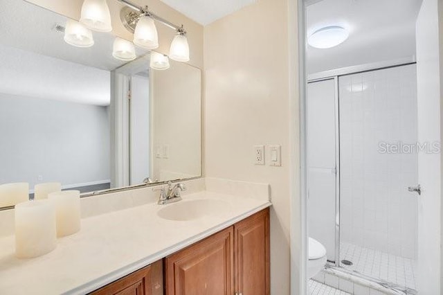 bathroom with vanity, a shower stall, and toilet