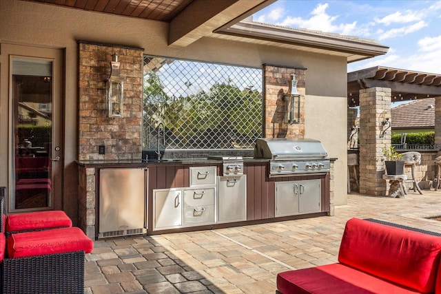 view of patio / terrace featuring a sink, grilling area, an outdoor kitchen, and fence