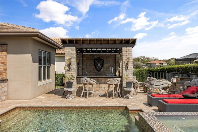 view of patio with a fenced in pool, outdoor dry bar, a fireplace, and fence