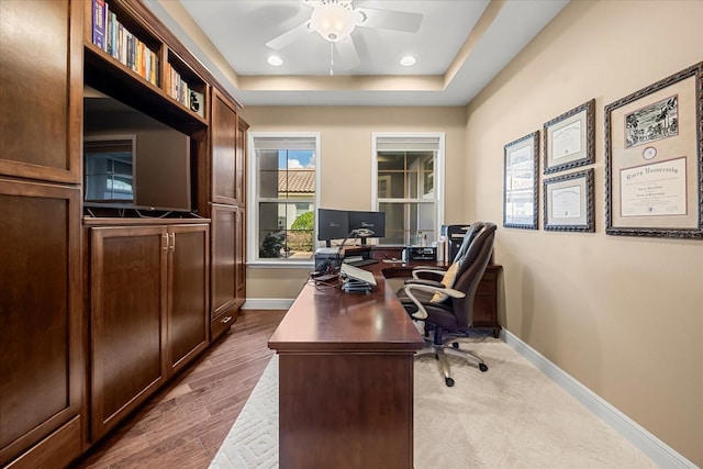 office with wood finished floors, a ceiling fan, baseboards, recessed lighting, and a raised ceiling