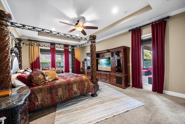 carpeted bedroom featuring a raised ceiling, baseboards, and ceiling fan