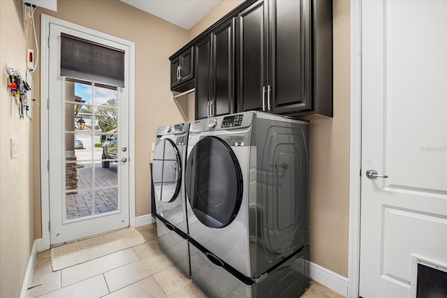 washroom featuring light tile patterned floors, cabinet space, baseboards, and separate washer and dryer