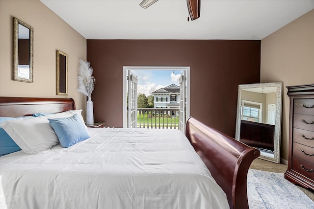 bedroom featuring access to outside, multiple windows, a ceiling fan, and carpet floors