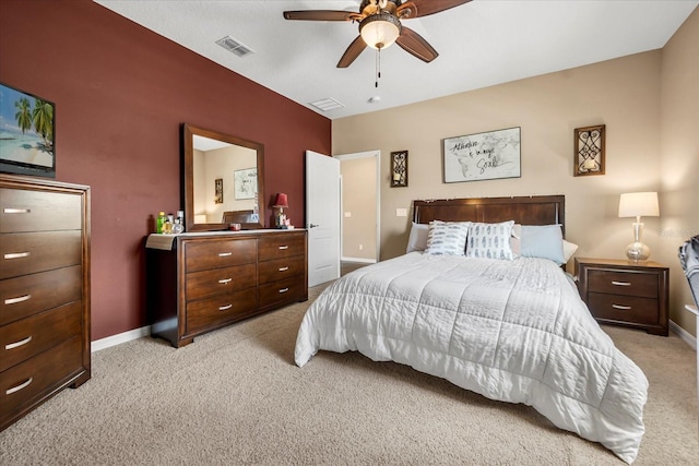 bedroom featuring a ceiling fan, light colored carpet, visible vents, and baseboards