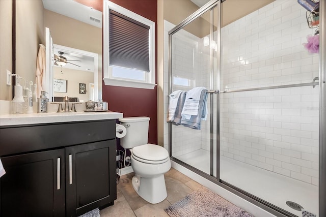 bathroom featuring vanity, a stall shower, ceiling fan, tile patterned floors, and toilet