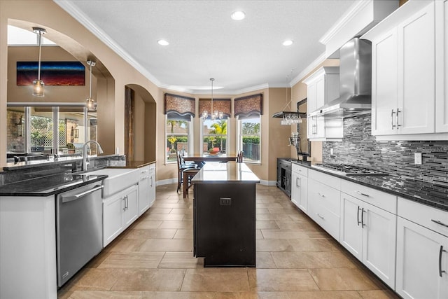 kitchen with tasteful backsplash, a center island, stainless steel appliances, wall chimney exhaust hood, and a sink