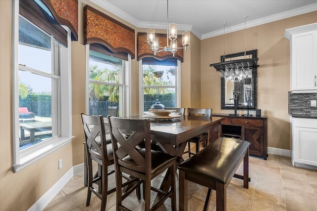 dining room featuring baseboards, a chandelier, and ornamental molding