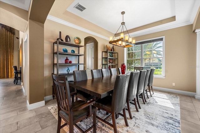 dining area with visible vents, a raised ceiling, arched walkways, and a chandelier