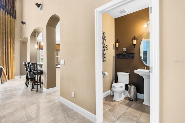 bathroom with toilet, baseboards, and visible vents