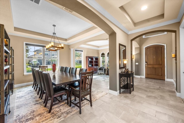 dining space with a raised ceiling, a healthy amount of sunlight, and a chandelier