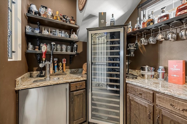 bar with indoor wet bar, refrigerator, and beverage cooler