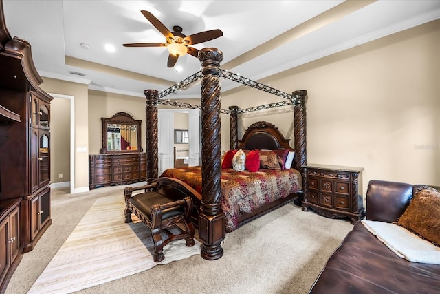 bedroom featuring visible vents, light carpet, ornamental molding, a tray ceiling, and baseboards