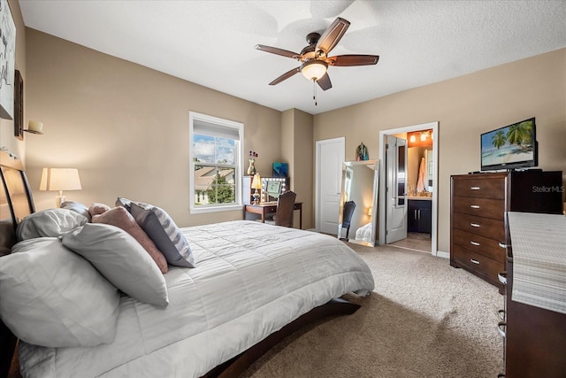 carpeted bedroom with ceiling fan, a textured ceiling, connected bathroom, and baseboards