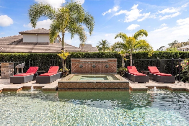 view of swimming pool with an in ground hot tub, fence, and a patio