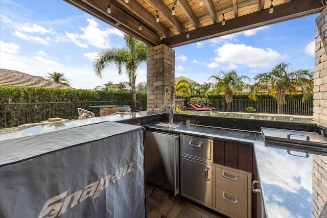 view of patio featuring area for grilling and fence