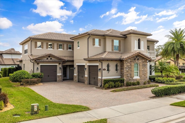 view of front of property featuring stone siding, stucco siding, an attached garage, and decorative driveway