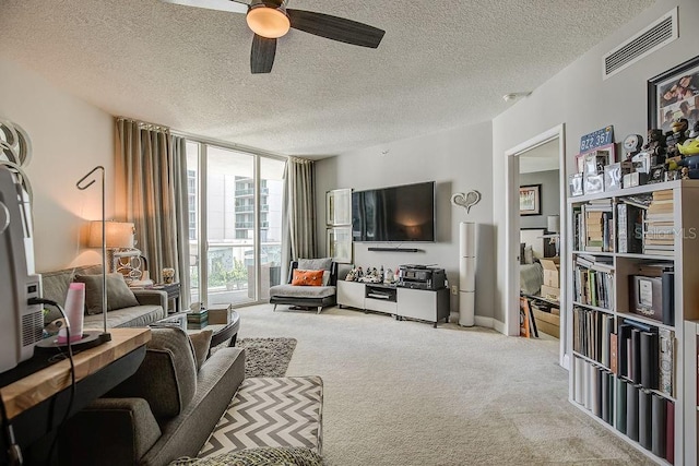 living area with floor to ceiling windows, carpet flooring, visible vents, and a textured ceiling