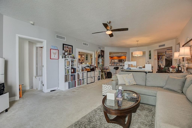 living area featuring visible vents, a textured ceiling, ceiling fan, and carpet floors