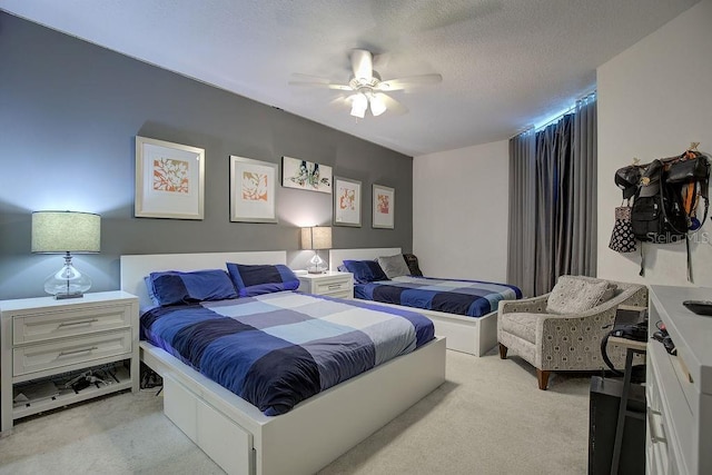 bedroom with light colored carpet, a textured ceiling, and a ceiling fan