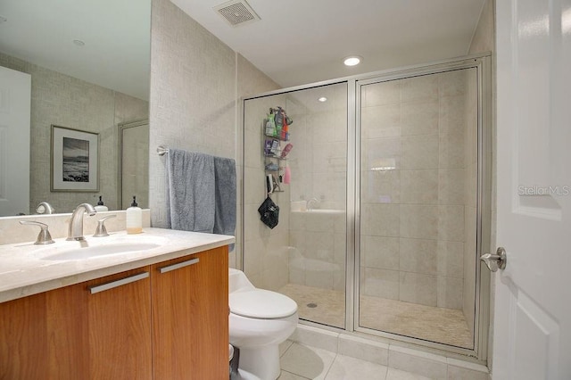 bathroom with vanity, visible vents, a shower stall, tile patterned floors, and toilet