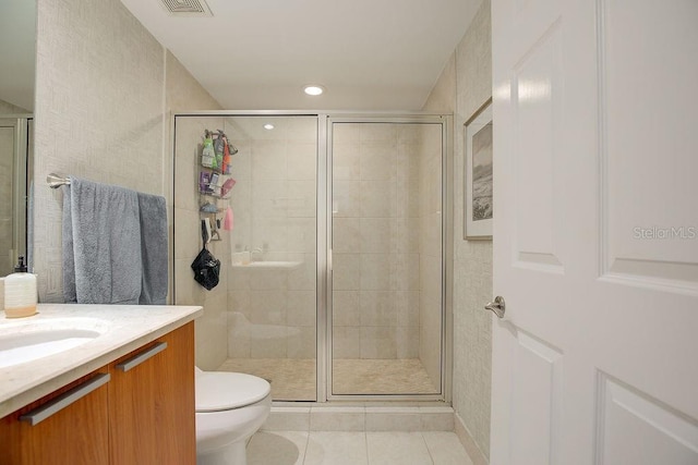 full bath featuring tile patterned flooring, toilet, vanity, and a stall shower