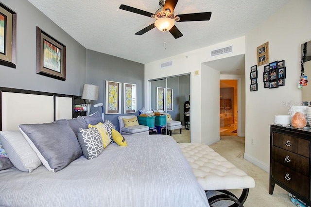 bedroom featuring light colored carpet, visible vents, a closet, and a textured ceiling