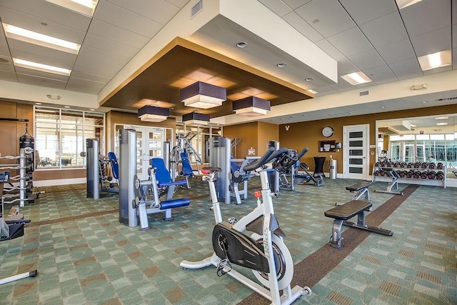 workout area with visible vents, baseboards, and carpet floors