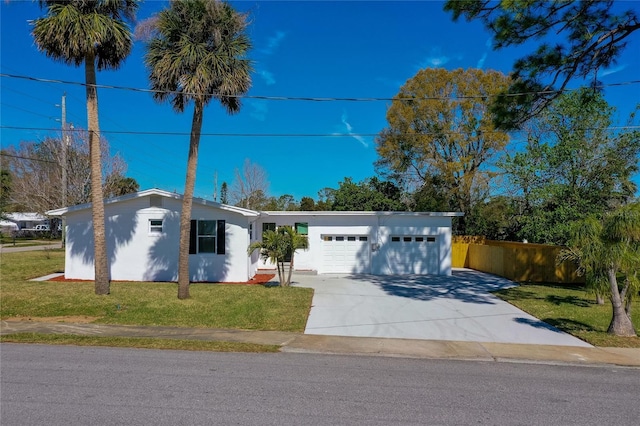 view of front of home featuring a front yard, concrete driveway, an attached garage, and stucco siding