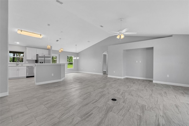 1329 N Old Mill Dr, Deltona, FL 32725 - unfurnished living room with baseboards, lofted ceiling, a healthy amount of sunlight, and a ceiling fan
