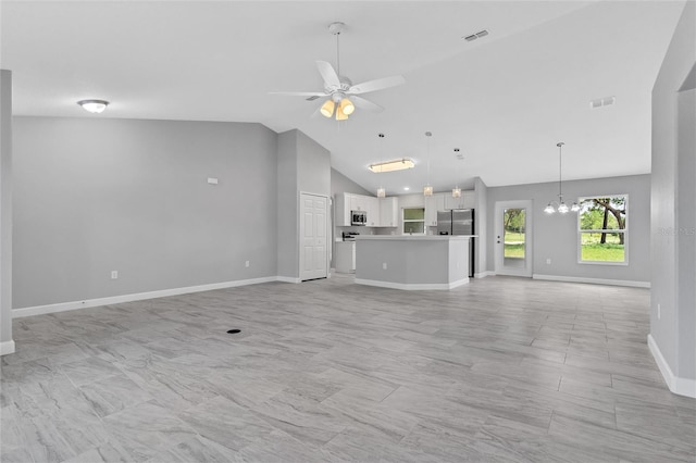 1329 N Old Mill Dr, Deltona, FL 32725 - unfurnished living room featuring visible vents, ceiling fan with notable chandelier, high vaulted ceiling, and baseboards