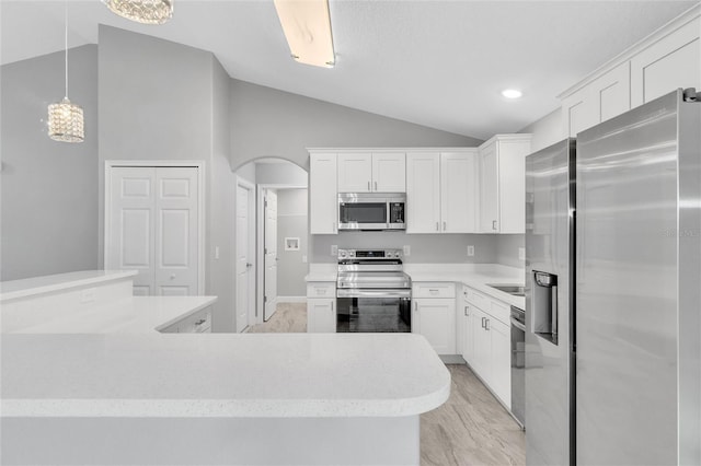 1329 N Old Mill Dr, Deltona, FL 32725 - kitchen featuring stainless steel appliances, arched walkways, white cabinets, light countertops, and lofted ceiling