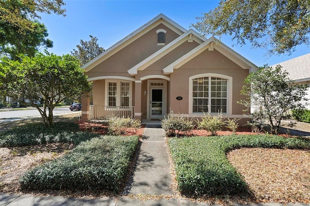 view of front of house featuring stucco siding and a porch