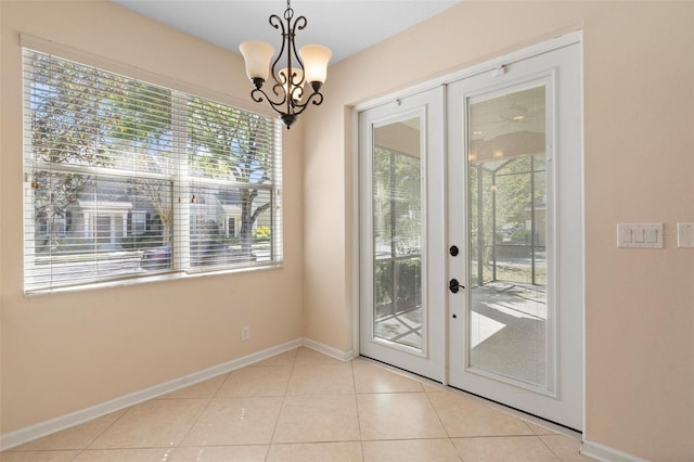 entryway featuring french doors, baseboards, an inviting chandelier, and tile patterned flooring