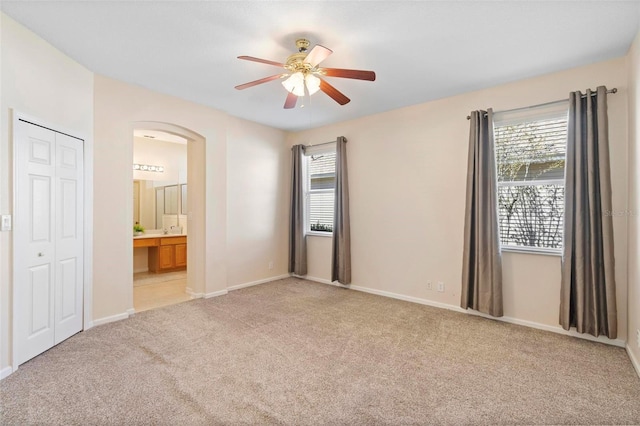 unfurnished room featuring ceiling fan, baseboards, and light carpet