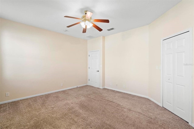 spare room with baseboards, visible vents, carpet floors, and ceiling fan