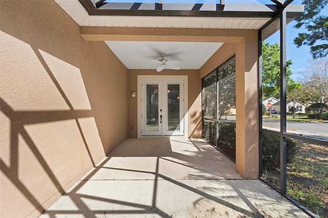 entrance to property with a patio area, stucco siding, french doors, and ceiling fan