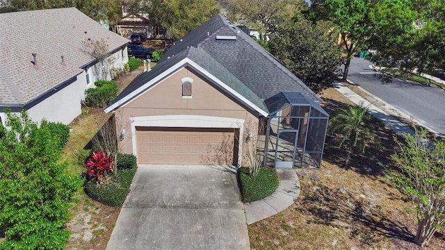 view of front of home featuring a shingled roof, a garage, driveway, and stucco siding