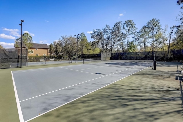 view of tennis court featuring fence