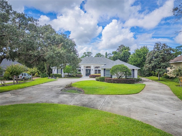 view of front facade with concrete driveway and a front yard